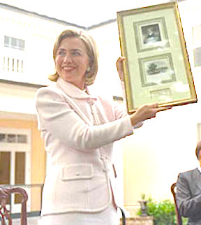 Showing the audience some memorabilia presented to her, Hillary Clinton at Montpelier during a ceremony honoring Dolley Madison. (WJCPL)