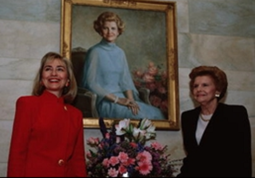 Hillary Clinton with Betty Ford, standing before the latter's White House portrait. (Getty)